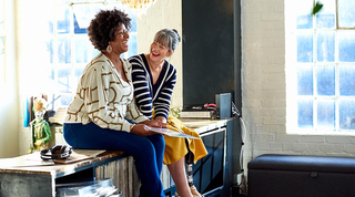 Two people sitting down, having an informal discussion and laughing